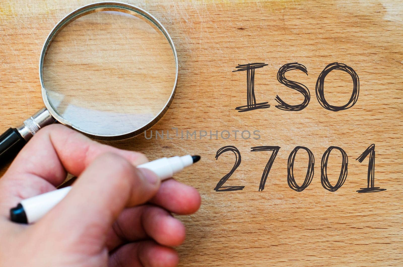 Human hand over wooden background and iso 27001 text concept