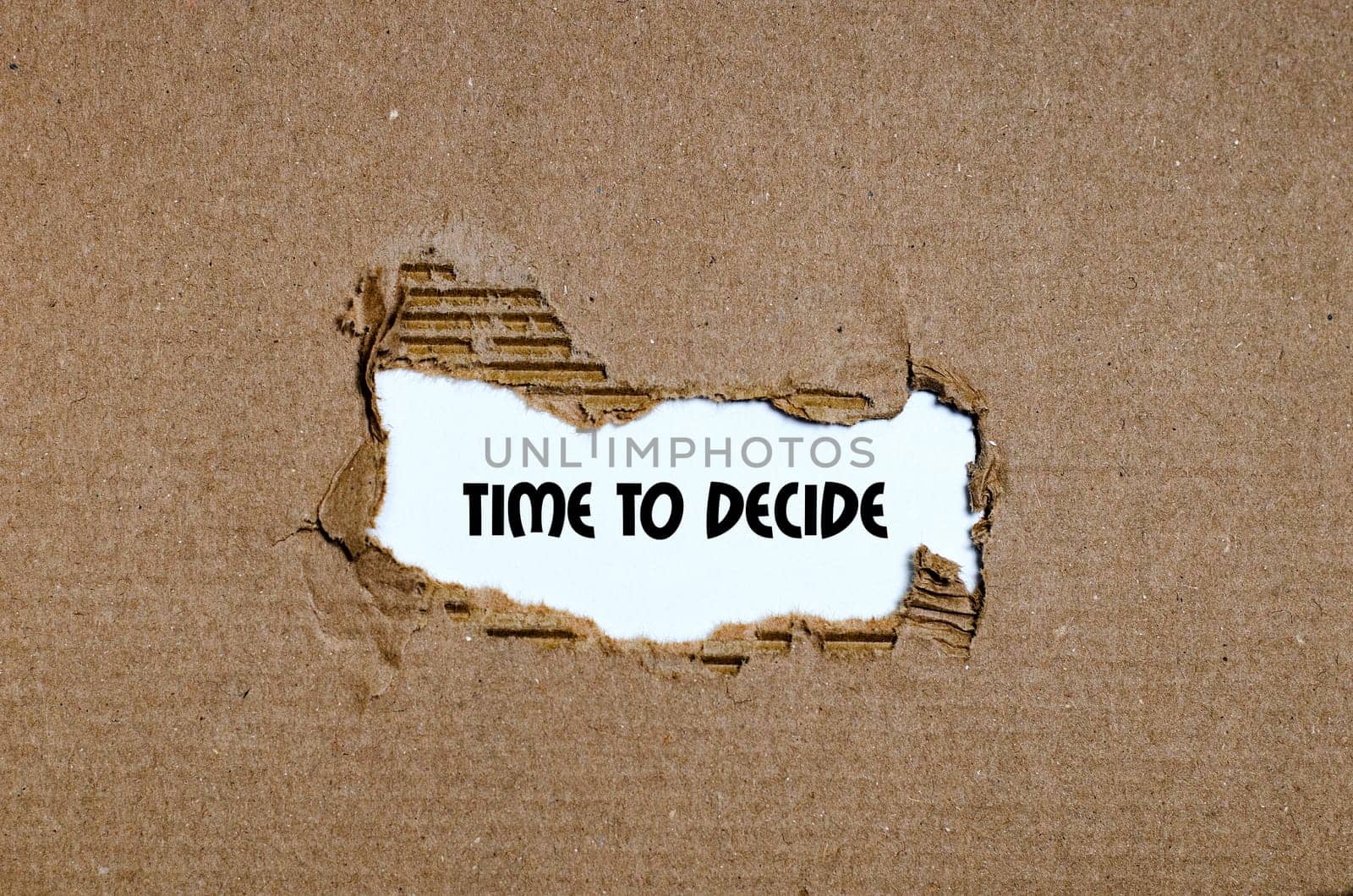 The word time to decide appearing behind torn paper