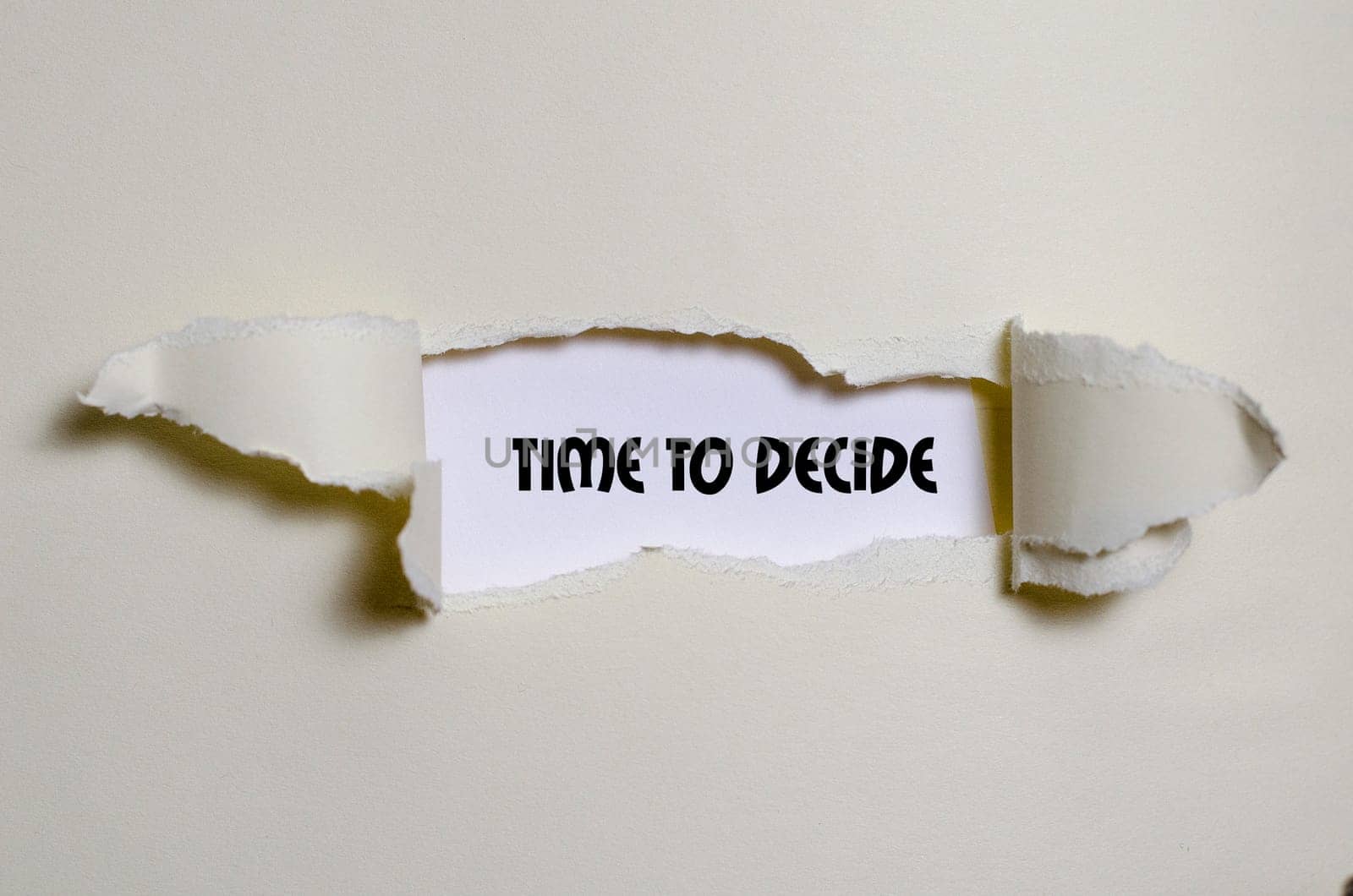 The word time to decide appearing behind torn paper