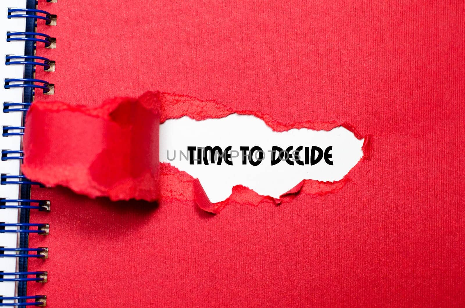 The word time to decide appearing behind torn paper