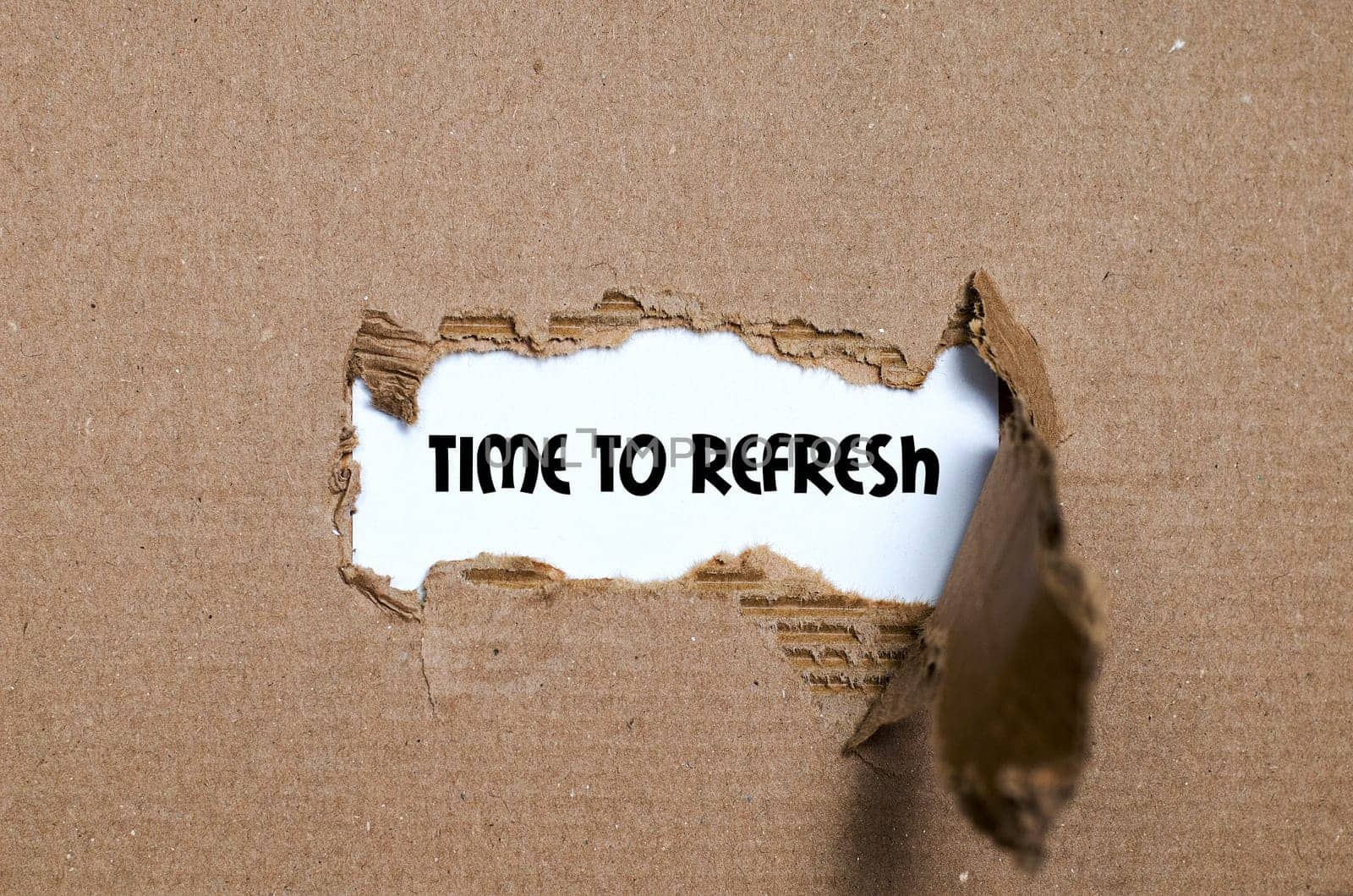 The word time to refresh appearing behind torn paper