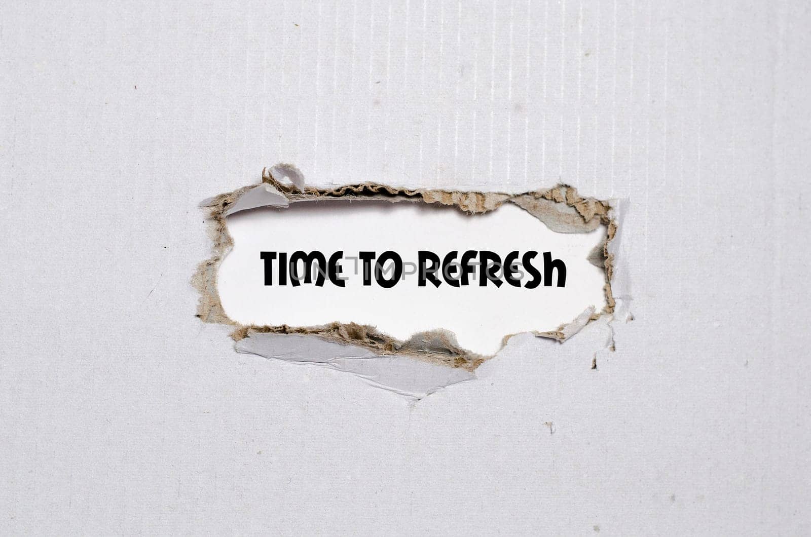 The word time to refresh appearing behind torn paper