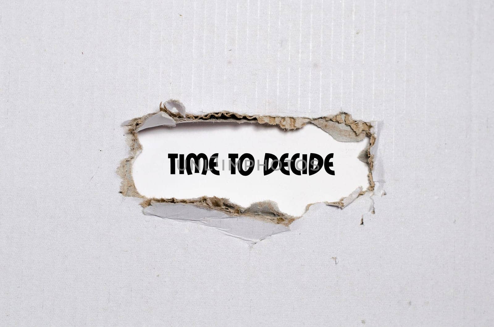 The word time to decide appearing behind torn paper