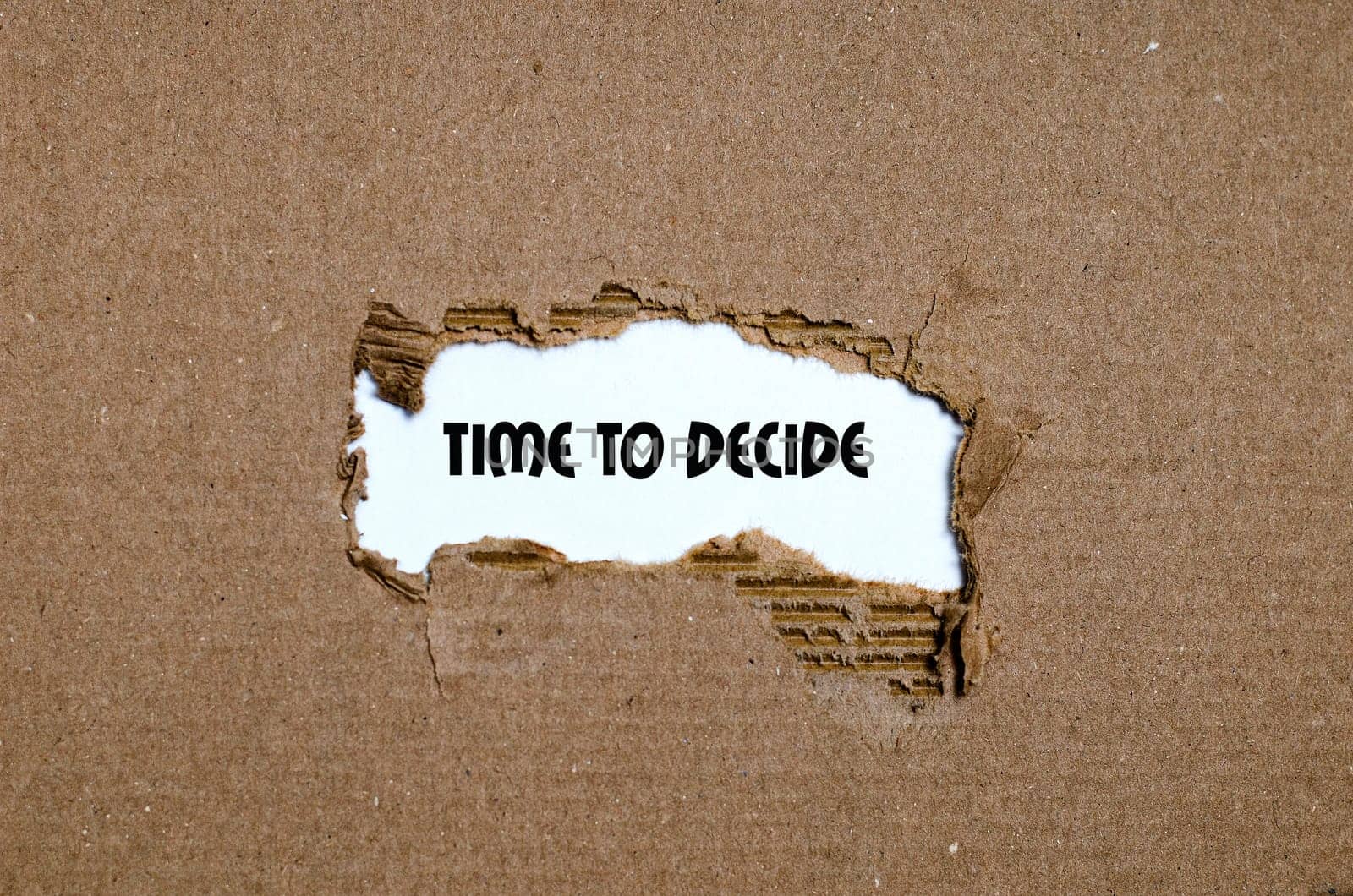The word time to decide appearing behind torn paper
