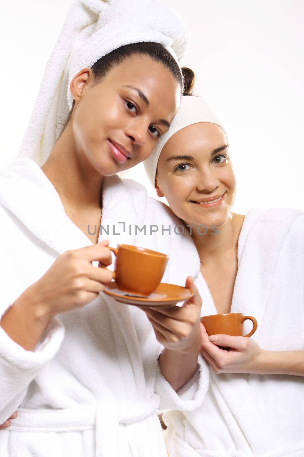 relax in the beauty salon,coffee with a friend. coffee,relax and beauty women in a beauty salon. two women in a wellness salon dressed in white bathrobes with cups of coffee
