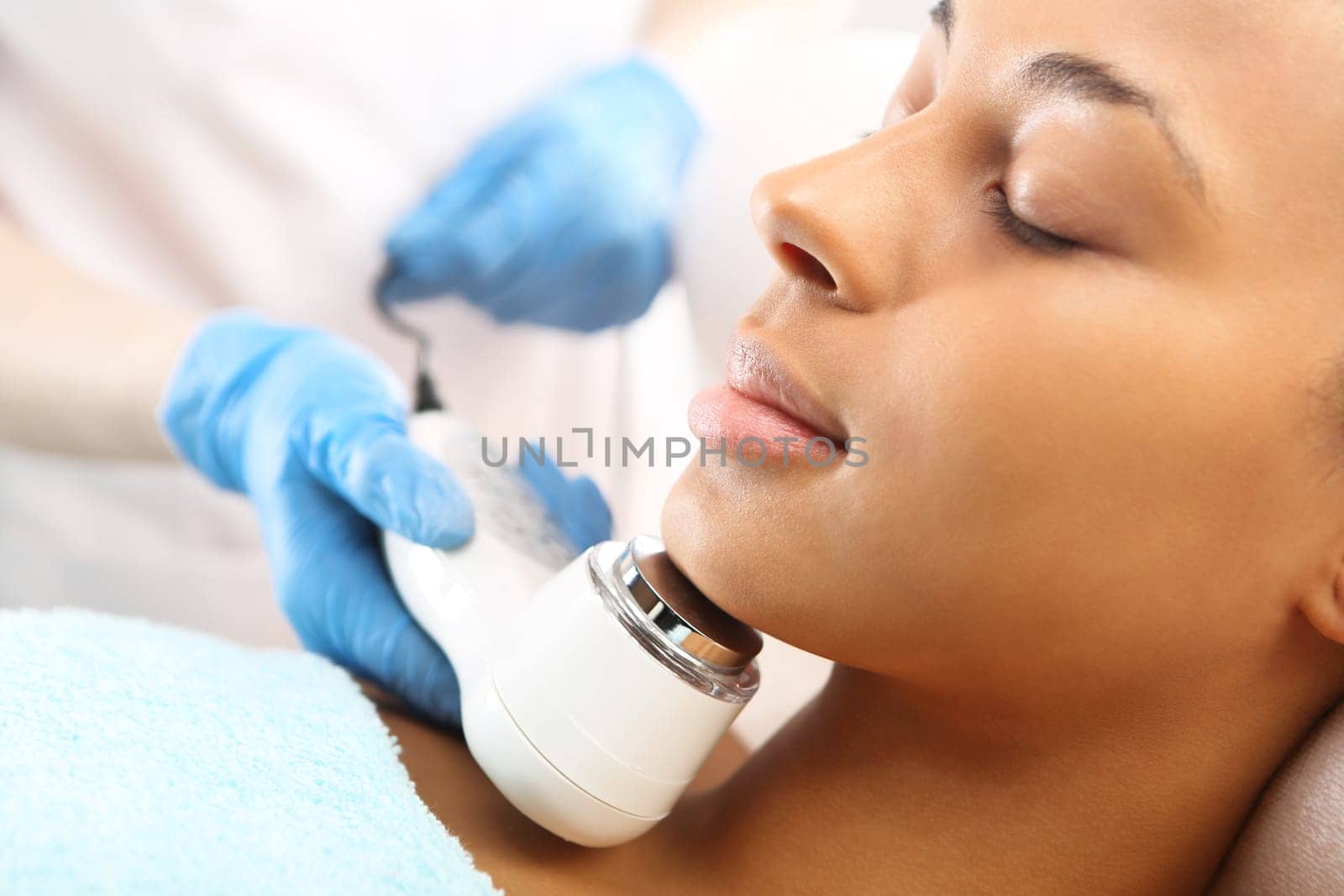 a woman's face during a treatment at a beauty salon\nultrasound infrared light,facial treatment\nultrasounds,a woman in a beauty salon\nlight therapy,a woman in a beauty salon\nacne treatment with light,a woman in a beauty salon