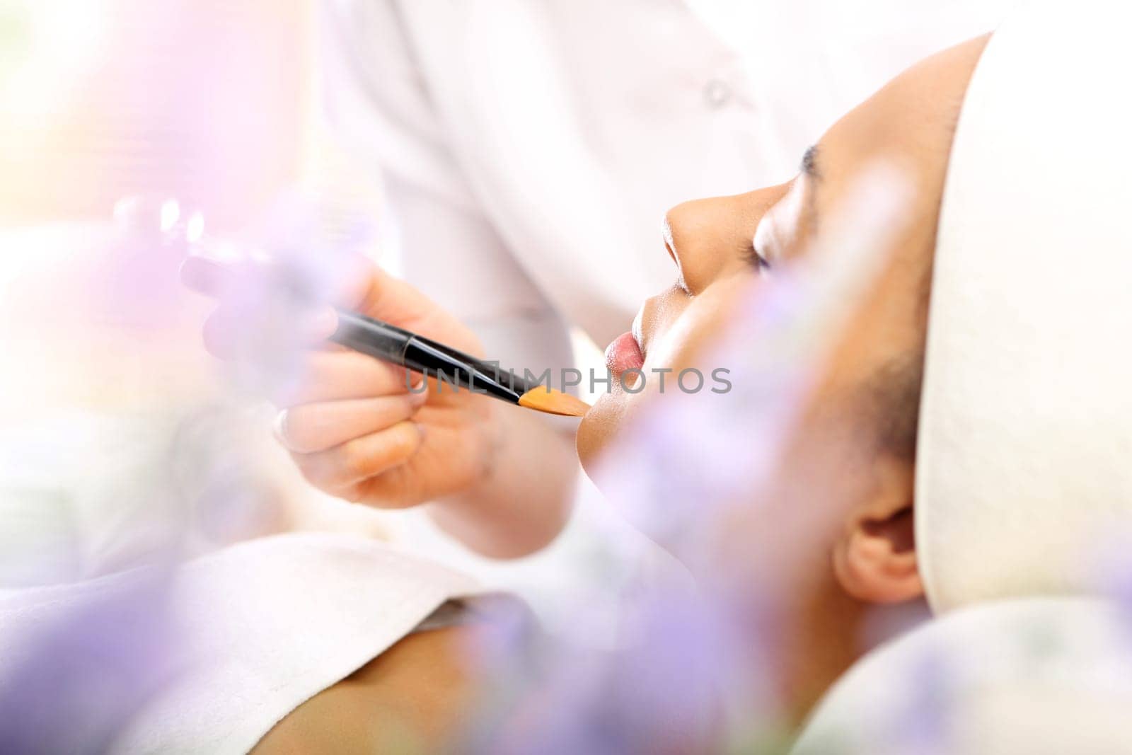 Beautician applies makeup to a woman's face. Beauty treatment in a beauty salon