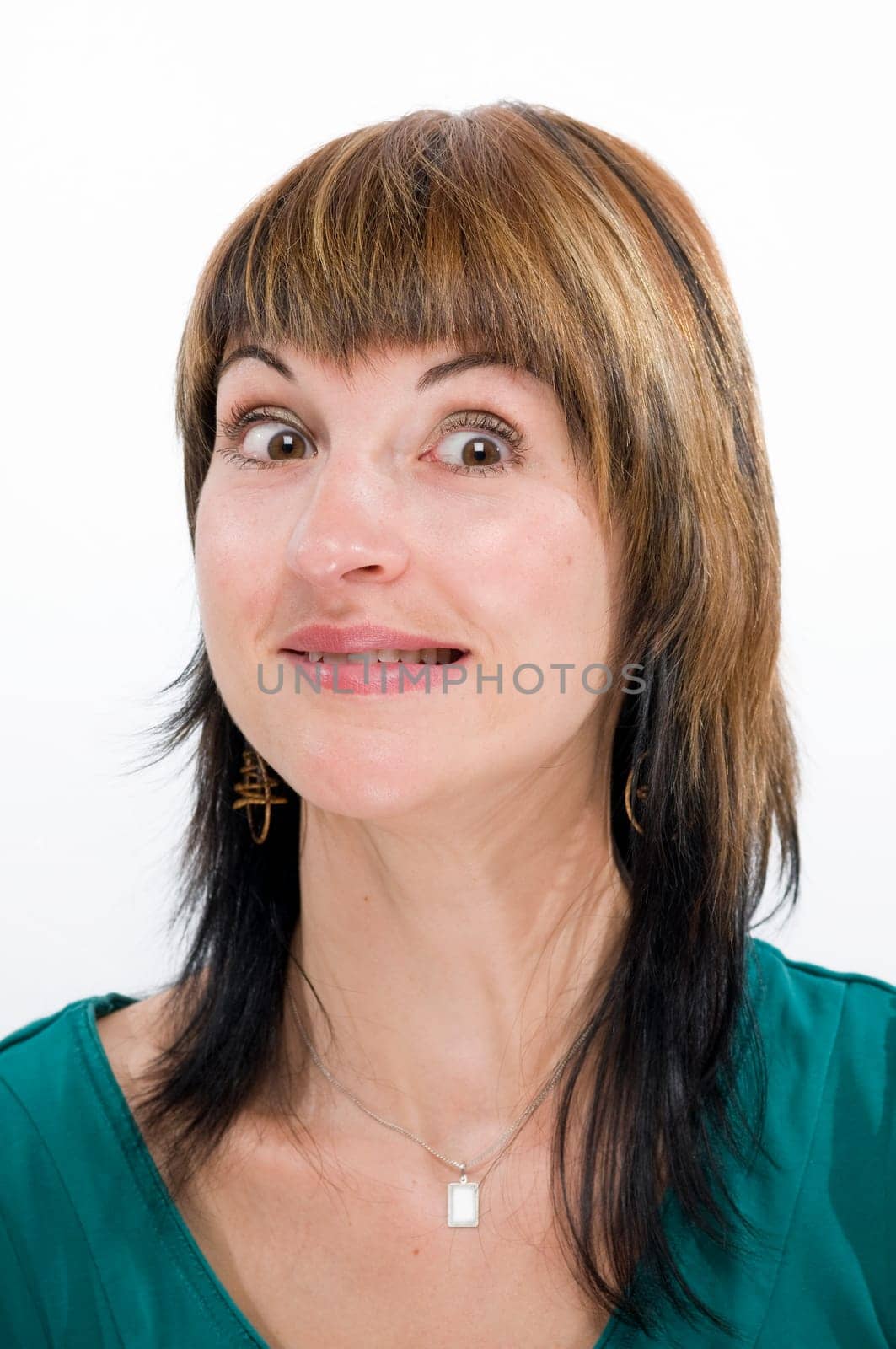Head portrait of a young brunette woman against a white background,looking doubtfully anxiously into the camera.