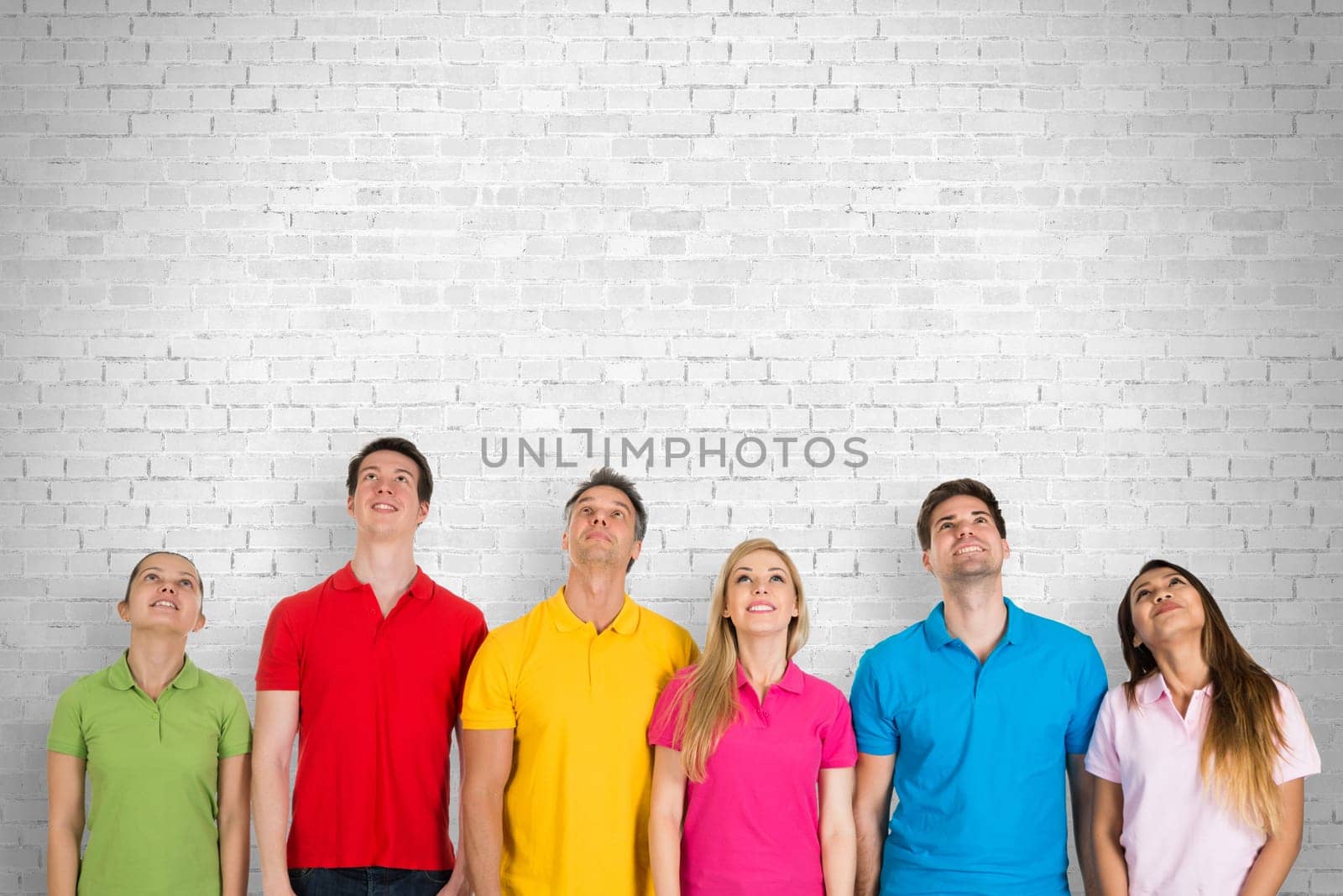 Multiethnic Group Of Friends Looking Up Over White Background