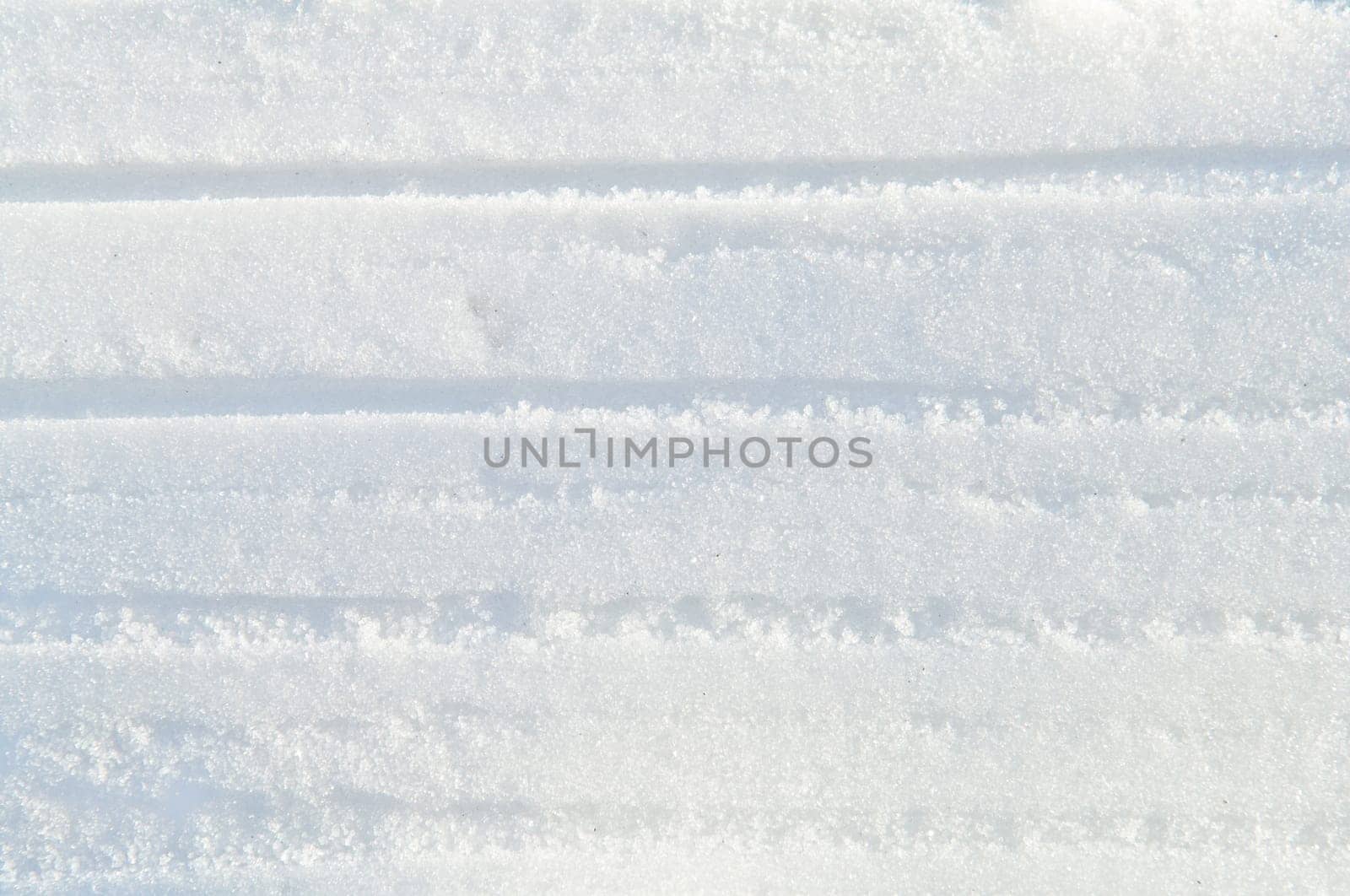 Winter snow background white snow flakes and crystals in natural light