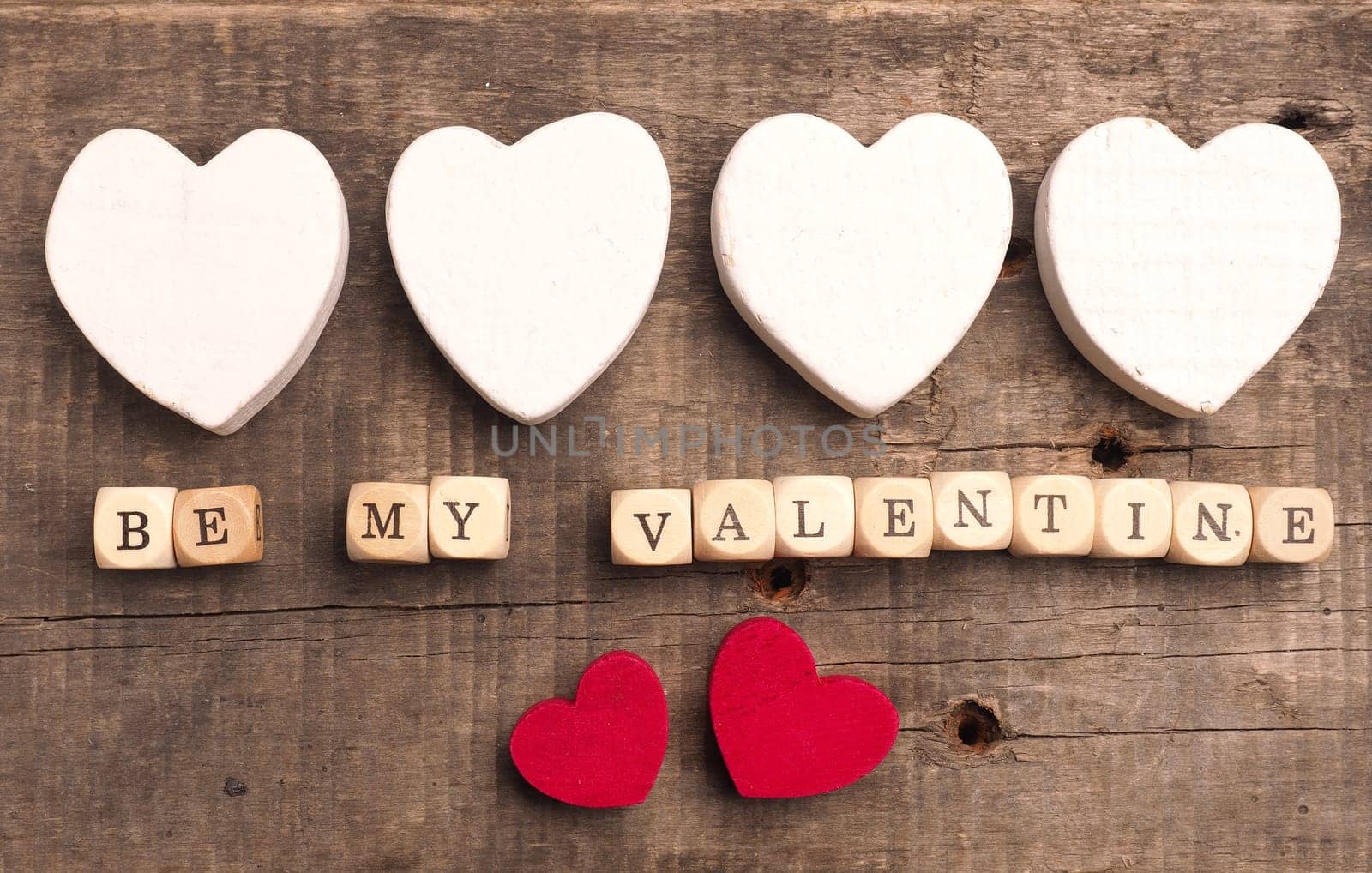 Wooden dices with heart shapes on a rustic wooden background, love concept image