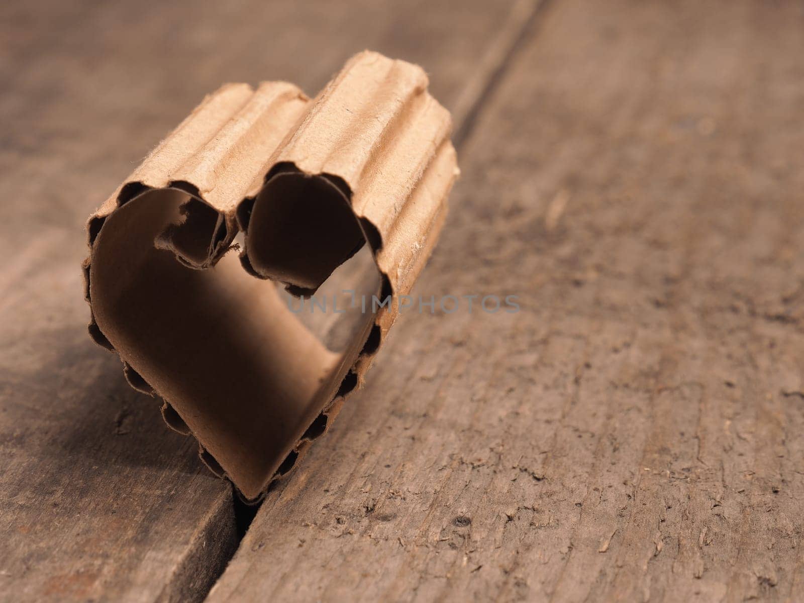 Love concept image with a cardboard heart shape on a rustic wooden table using as background or greeting card