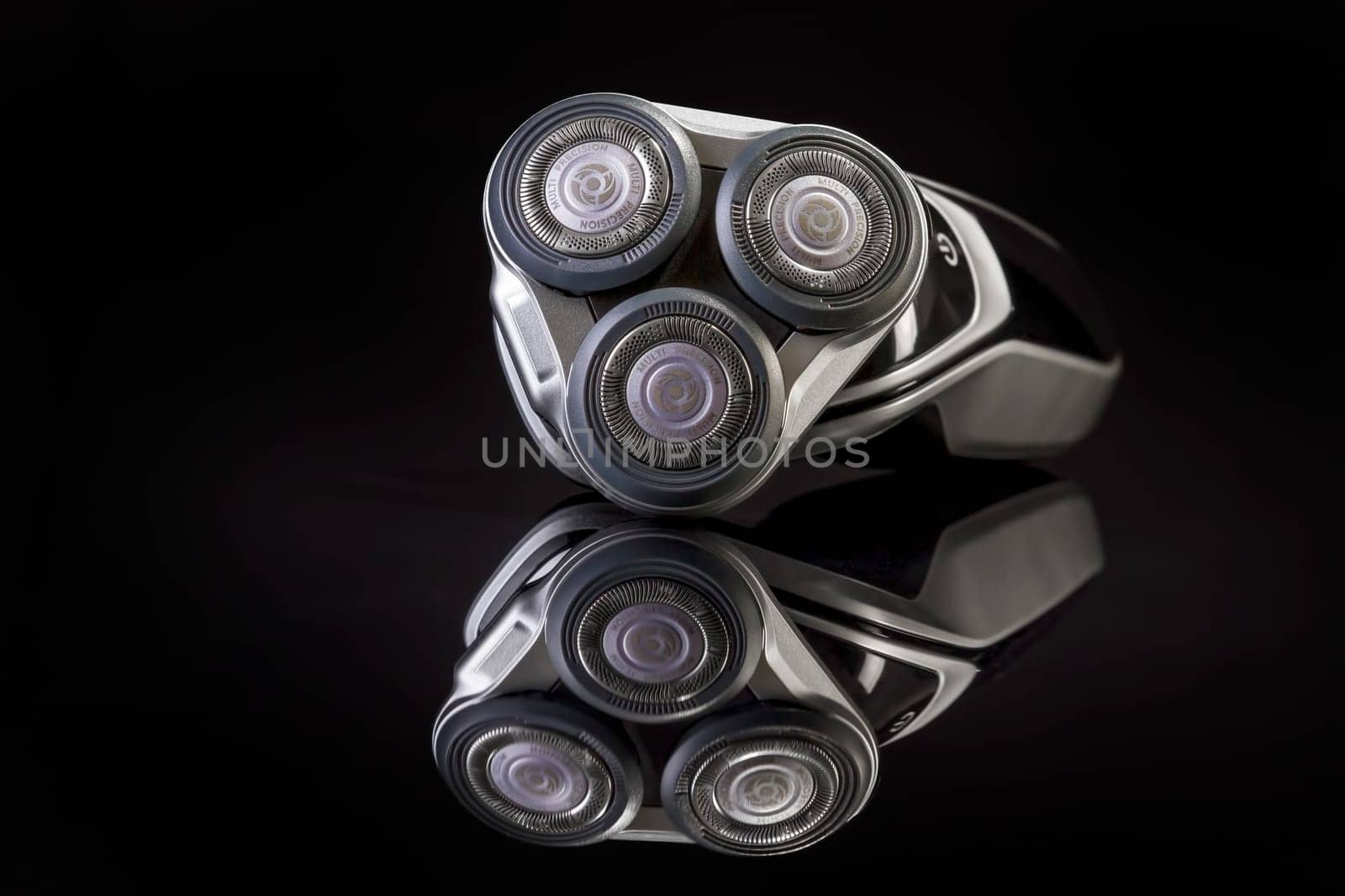 Electric shaver closeup on black background. Multi Precision text written on razor head! Best precision for shave!