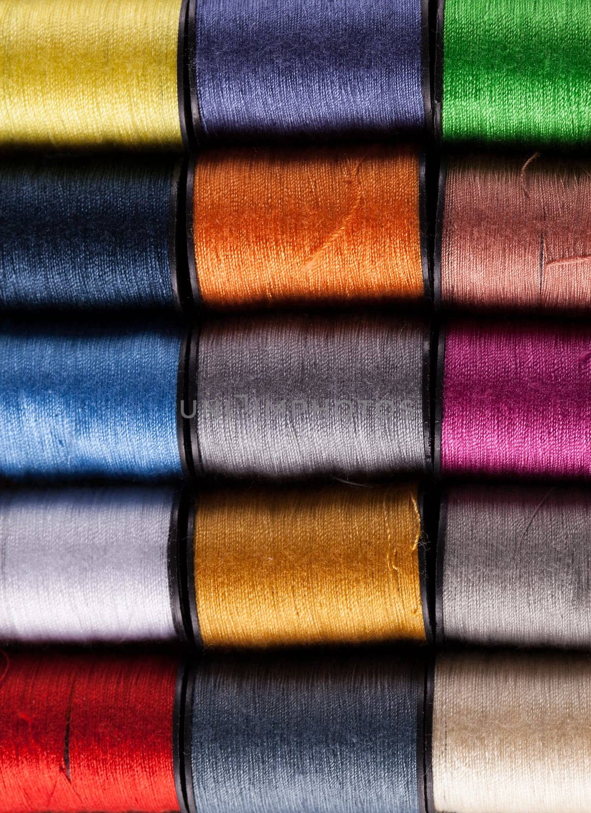 Colorful cotton reels lined up in a row and viewed from above
