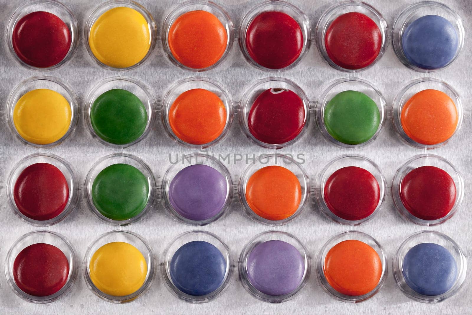Pills in a bubble pack viewed from above. Bright colours and round tablets sealed under plastic