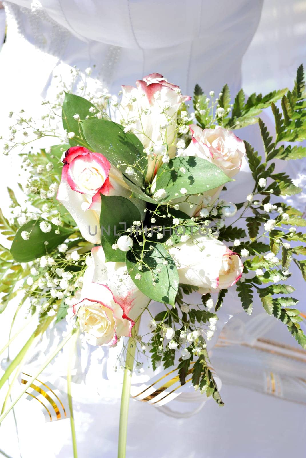 Beautiful white wedding bouquet in hands of the bride..