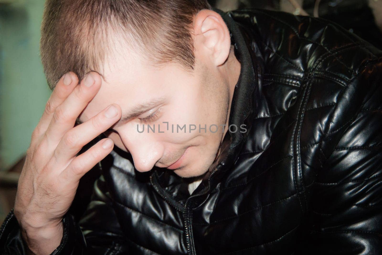 Portrait of the thoughtful young man with a hand at a forehead