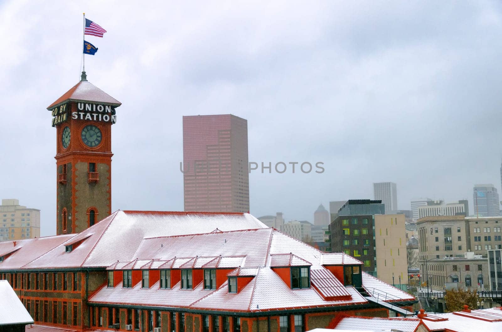 Train station and snow in Portland, Oregon with the Oregon and American flag flying above it