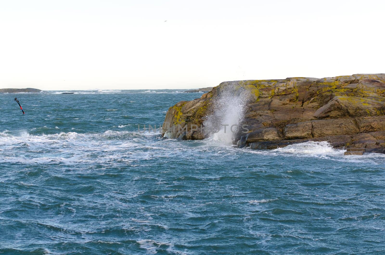 blowing on the swedish west coast and the waves splash on the rock