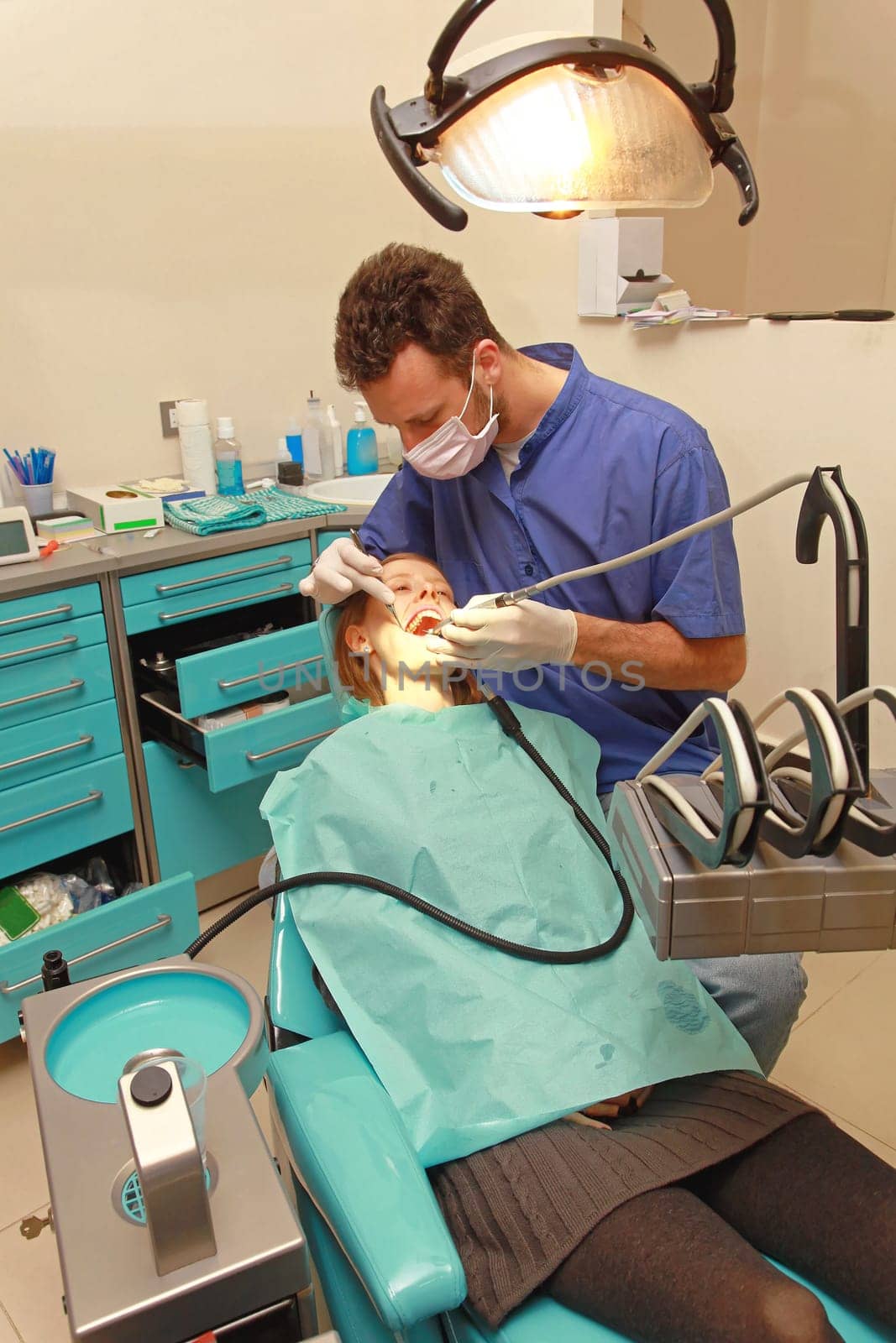 Dentist Drilling Tooth of Young Woman