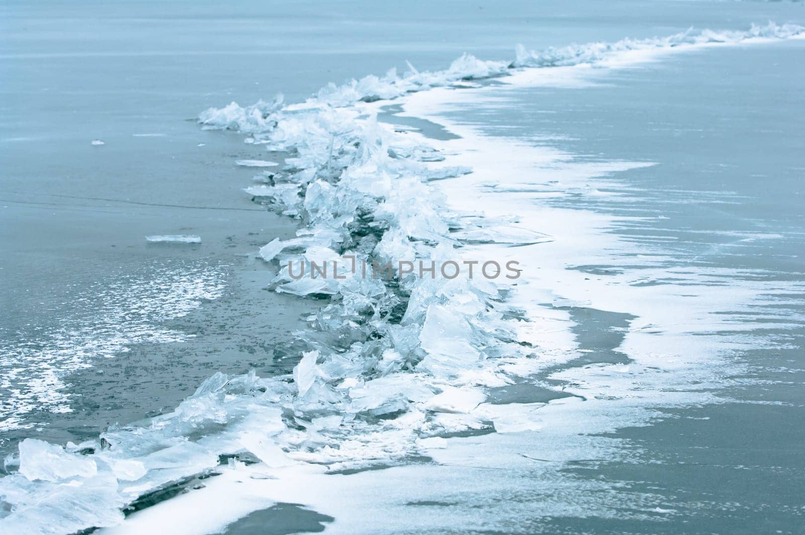 Winter scene at a frozen lake with ice-pack and other ice formations