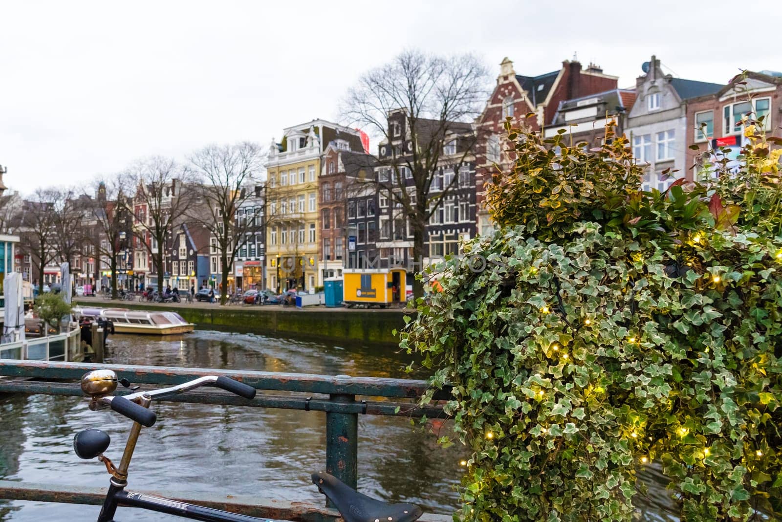 Amsterdam, Netherlands - January 9, 2017: Street view with traditional Dutch row houses and famous canals in Amsterdam historical city center, the Netherlands’ capital, known for its artistic heritage