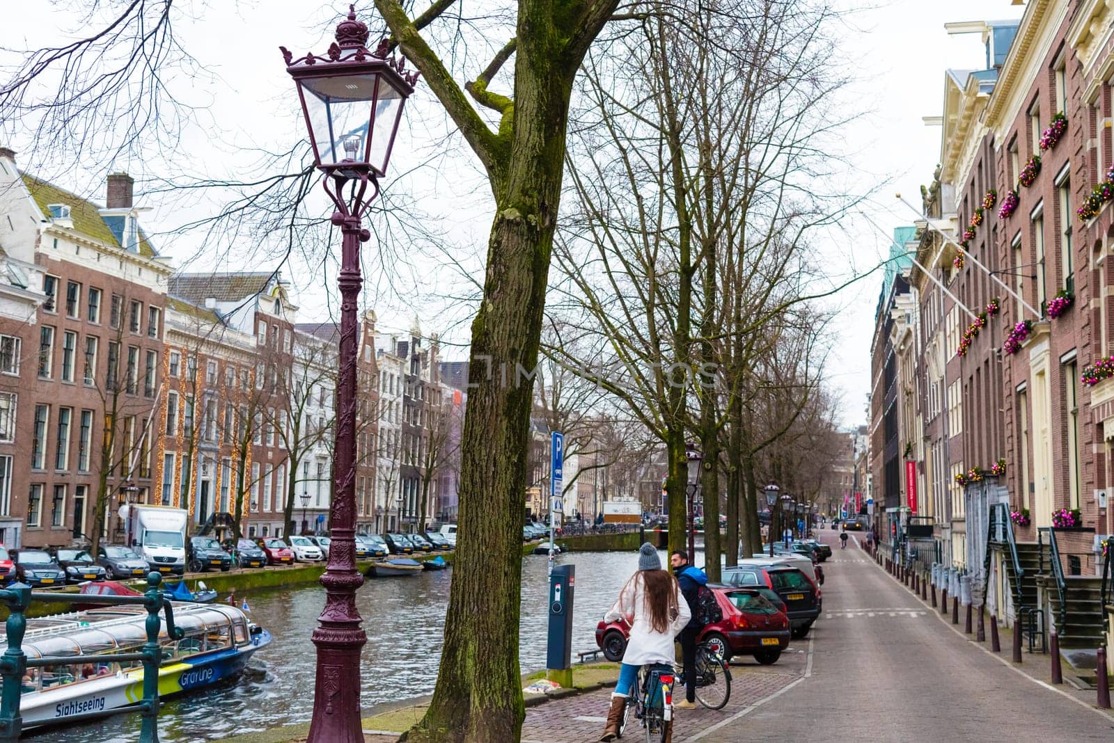 Amsterdam, Netherlands - January 9, 2017: Street view with traditional Dutch row houses and famous canals in Amsterdam historical city center, the Netherlands’ capital, known for its artistic heritage