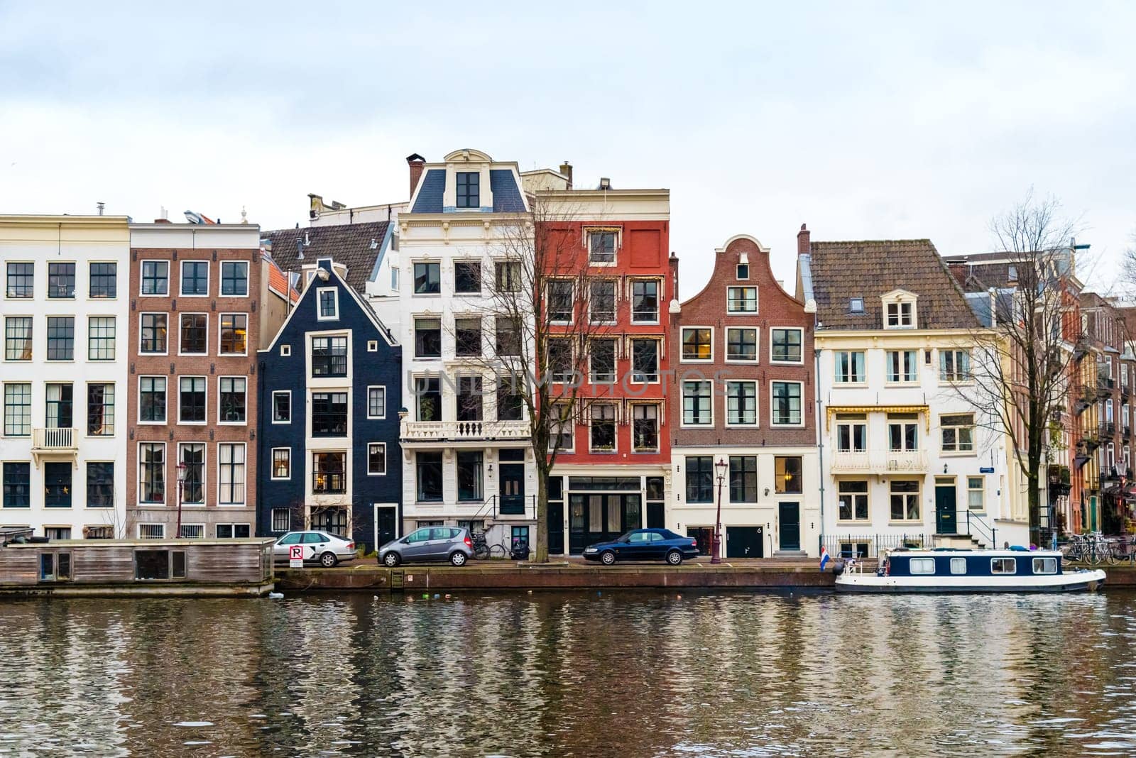 Amsterdam, Netherlands - January 9, 2017: Street view with traditional Dutch row houses and famous canals in Amsterdam historical city center, the Netherlands’ capital, known for its artistic heritage