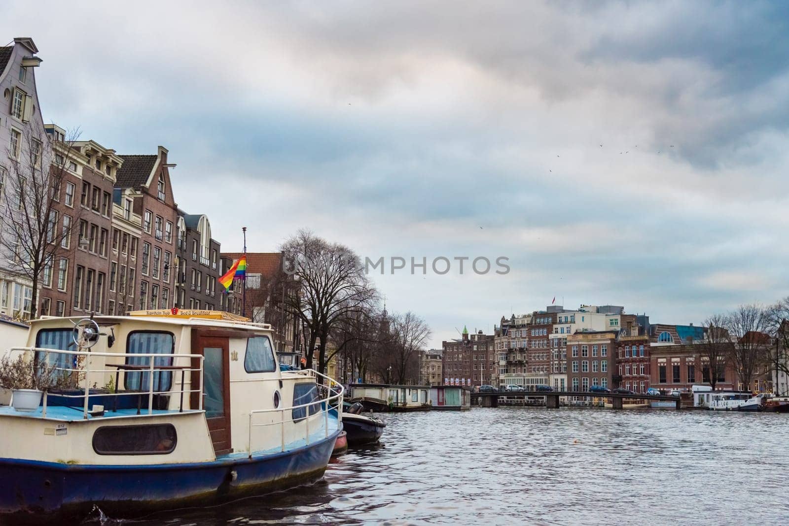 Amsterdam, Netherlands - January 9, 2017: Street view with traditional Dutch row houses and famous canals in Amsterdam historical city center, the Netherlands’ capital, known for its artistic heritage