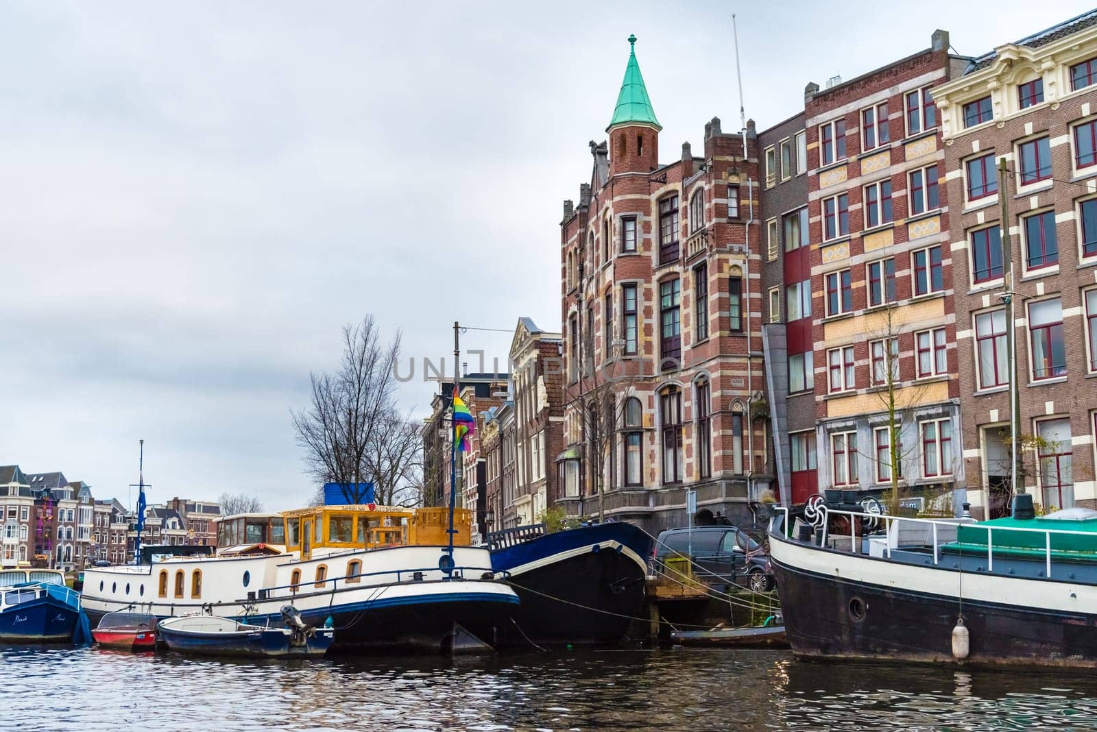 Amsterdam, Netherlands - January 9, 2017: Street view with traditional Dutch row houses and famous canals in Amsterdam historical city center, the Netherlands’ capital, known for its artistic heritage