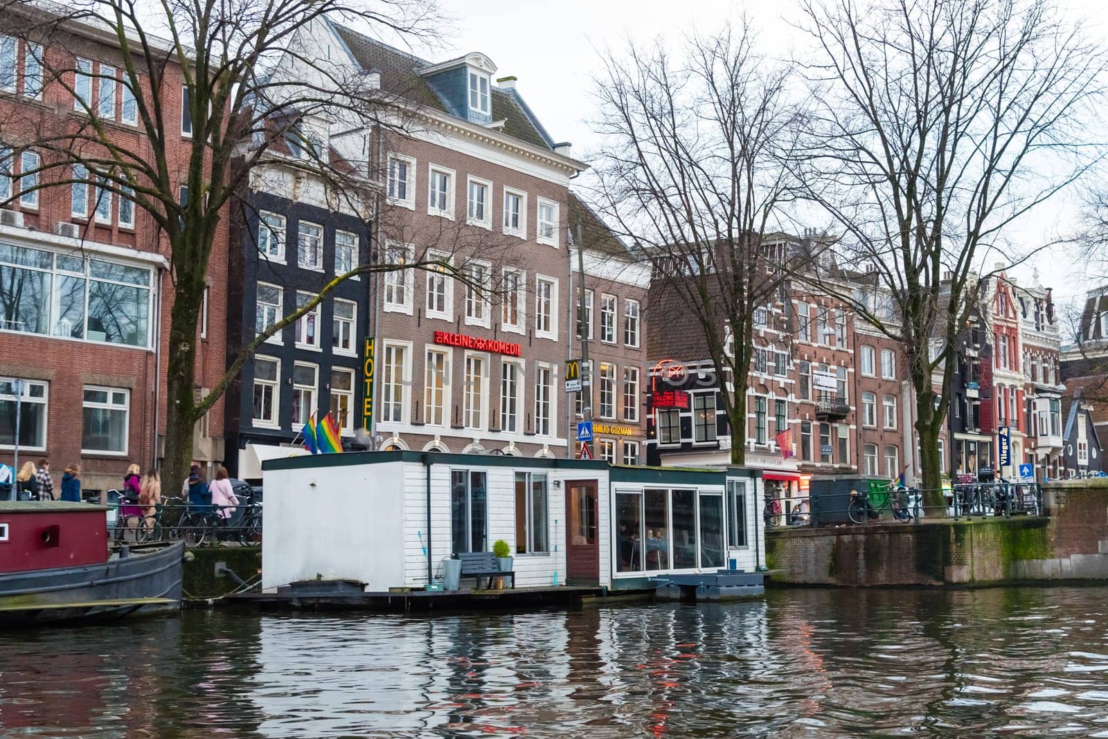 Amsterdam, Netherlands - January 9, 2017: Street view with traditional Dutch row houses and famous canals in Amsterdam historical city center, the Netherlands’ capital, known for its artistic heritage