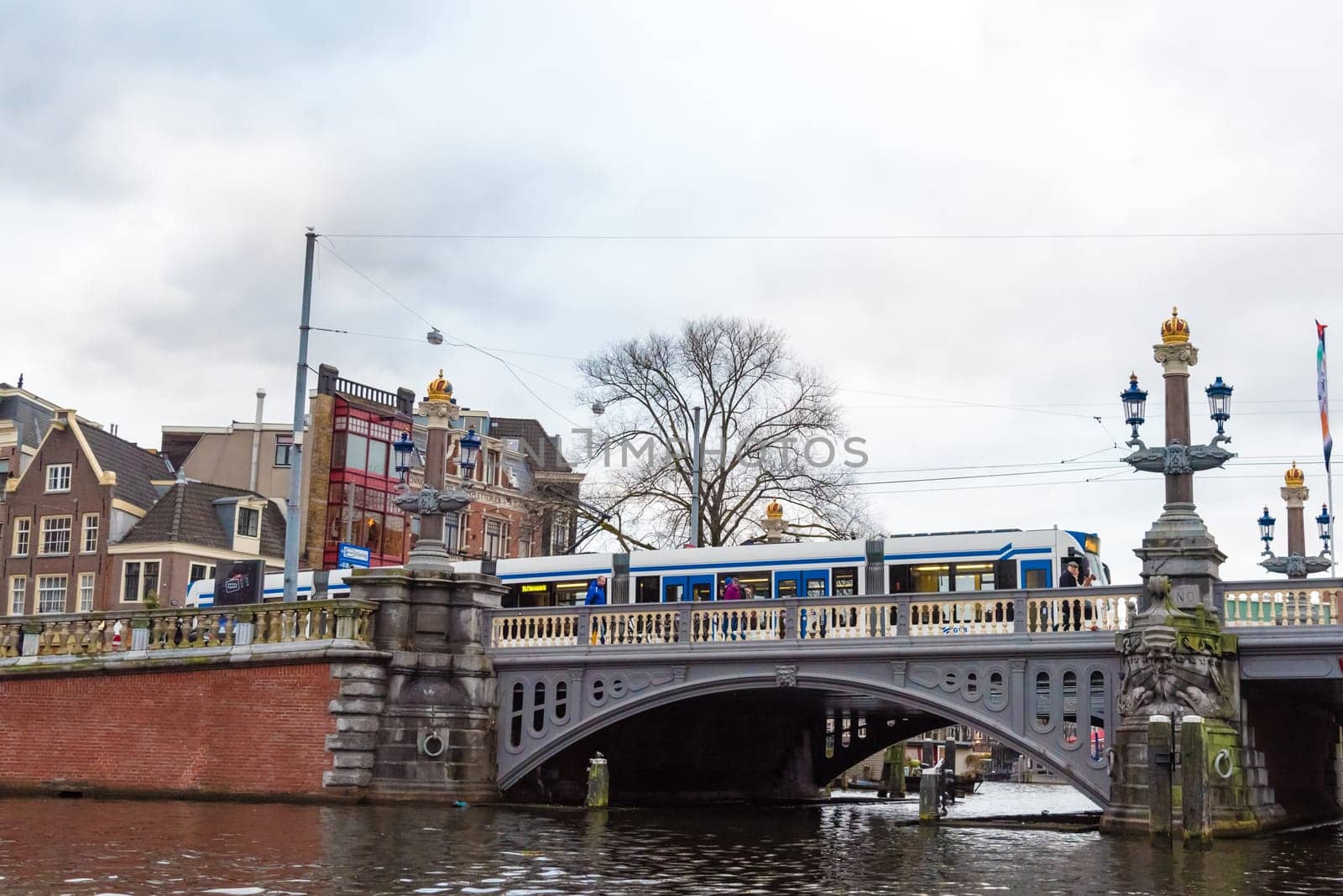 Amsterdam, Netherlands - January 9, 2017: Street view with traditional Dutch row houses and famous canals in Amsterdam historical city center, the Netherlands’ capital, known for its artistic heritage
