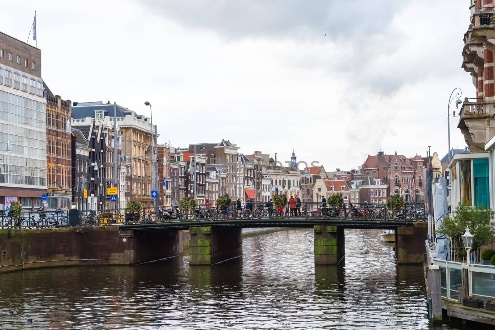 Amsterdam, Netherlands - January 9, 2017: Street view with traditional Dutch row houses and famous canals in Amsterdam historical city center, the Netherlands’ capital, known for its artistic heritage