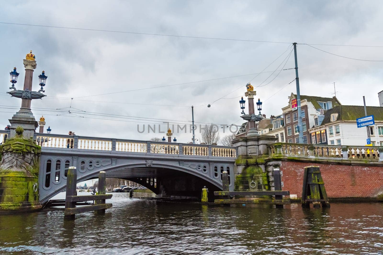 Amsterdam, Netherlands - January 9, 2017: Street view with traditional Dutch row houses and famous canals in Amsterdam historical city center, the Netherlands’ capital, known for its artistic heritage