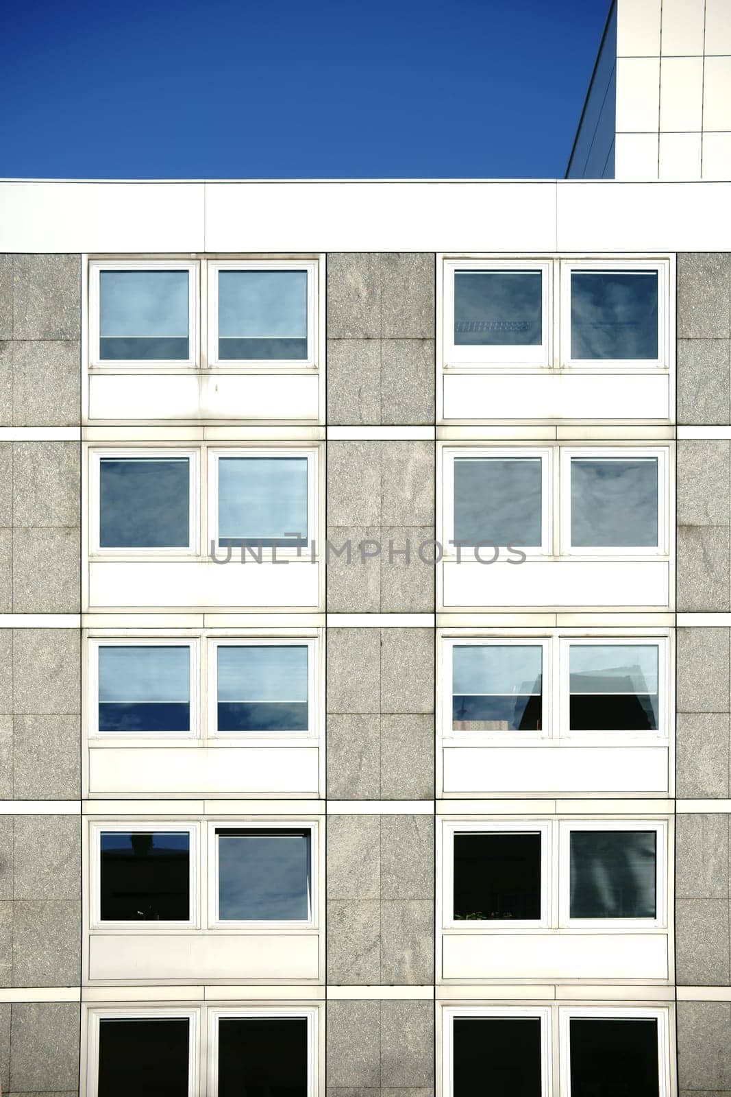 The angular exterior façade of a school building with large windows.