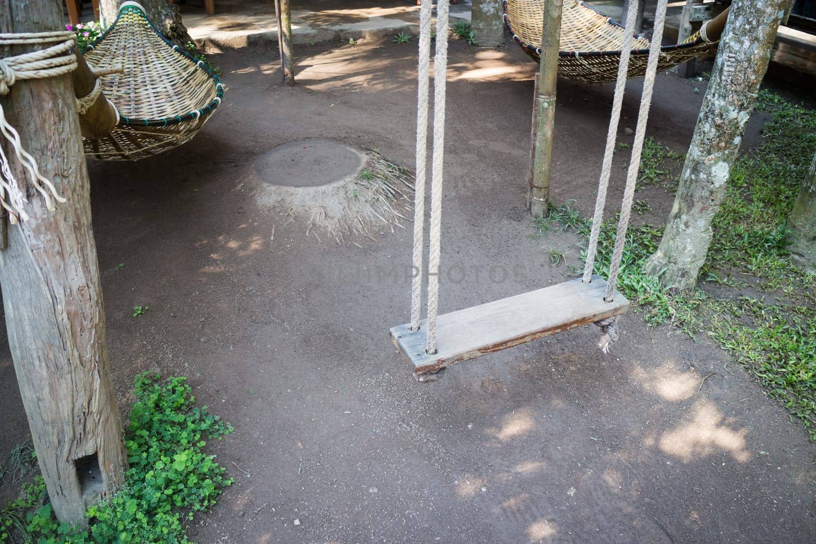 Empty wooden swing in the garden, stock photo