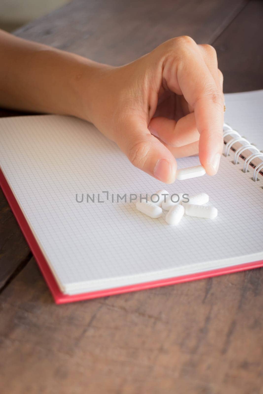 Hand on white pill medicine, stock photo