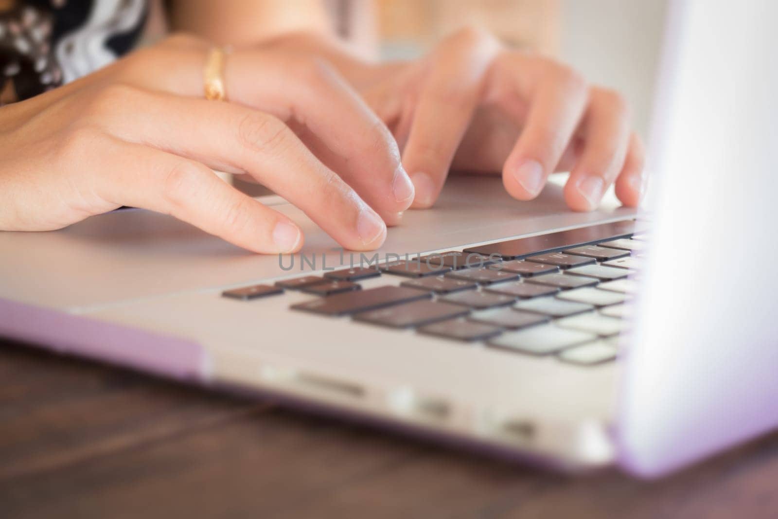 Typing on keyboard laptop at work table, stock photo