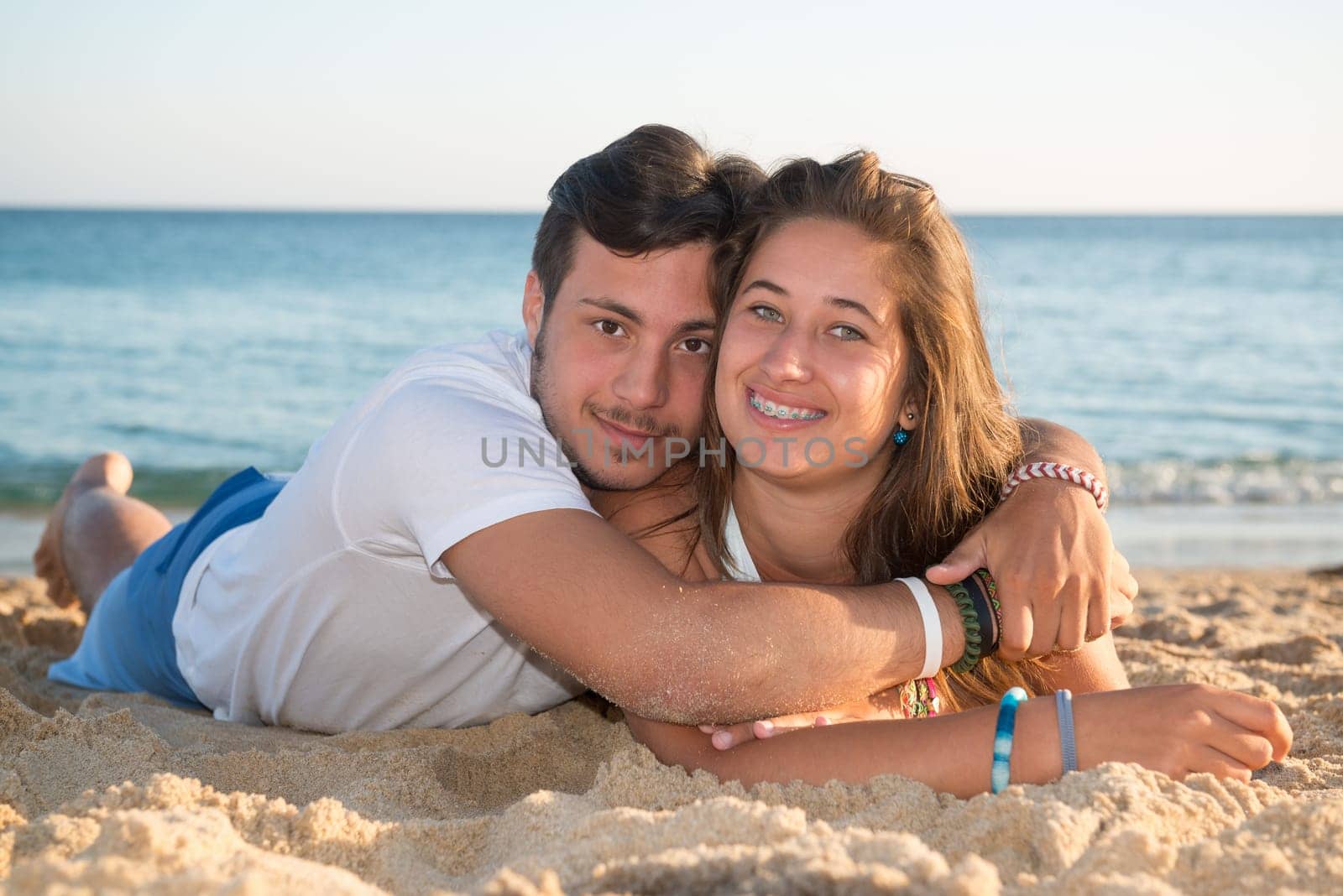 Happy teenage couple posing in the beach