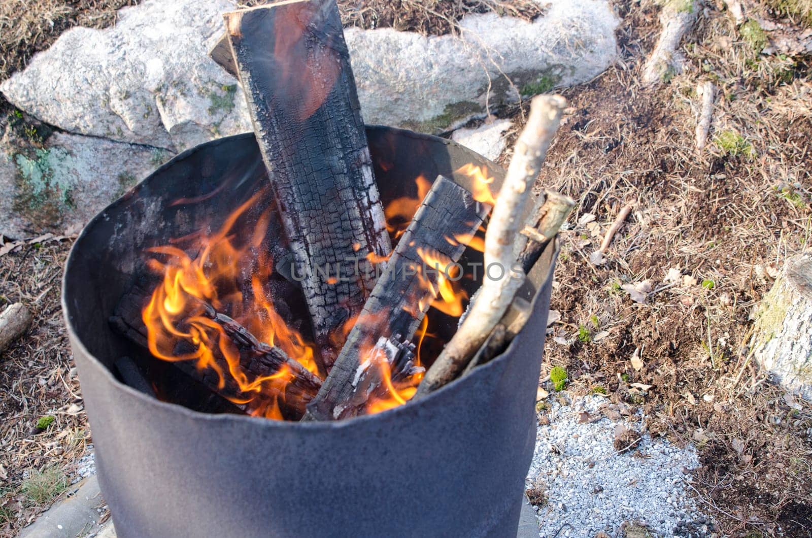 Fire in one old rusty barell standing in the nature