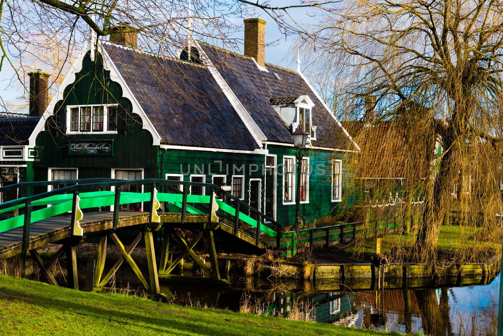 Zaanse Schans, Netherlands - January 10, 2017: Rural Dutch scenery with water canals in Zaanse Schans village known for well-preserved historic windmills and row houses near Amsterdam, Netherlands.