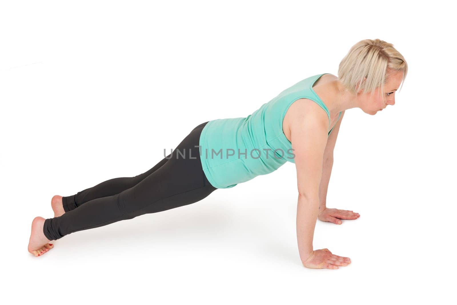 Full body view of a young blonde woman during yoga exercise "Cobra"" Step1 against a white background with a slight shadow."