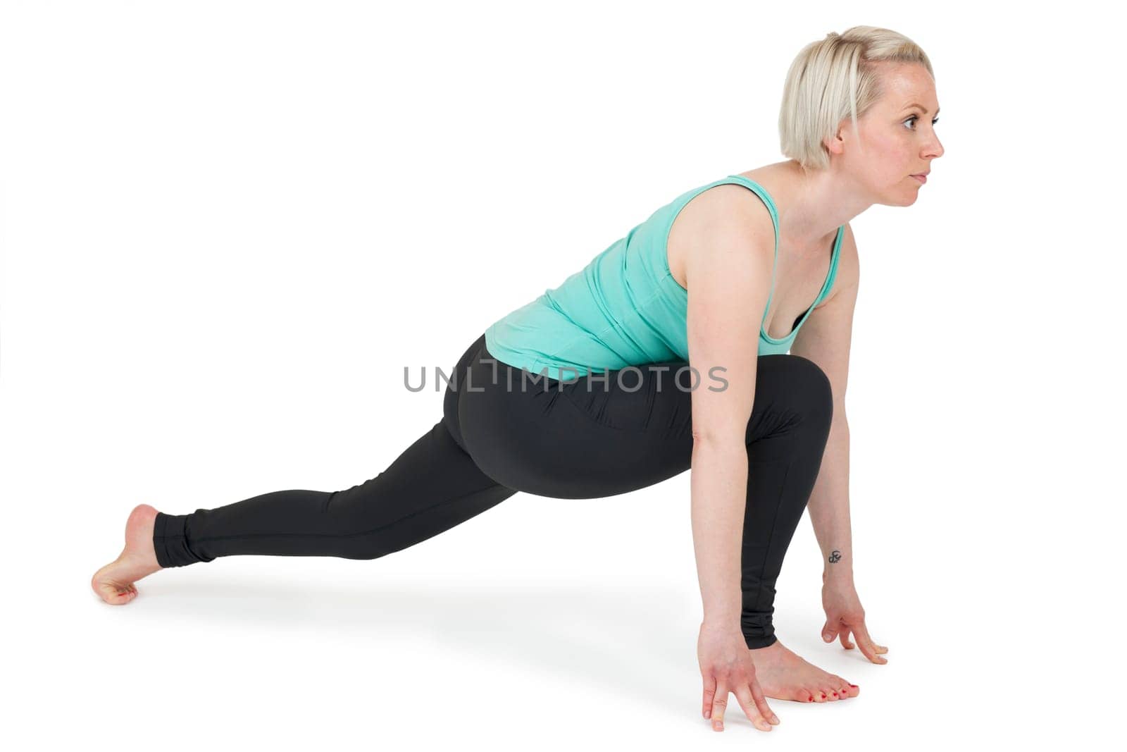 Full-body view of a young blonde woman doing yoga exercises against a white background with a slight shadow