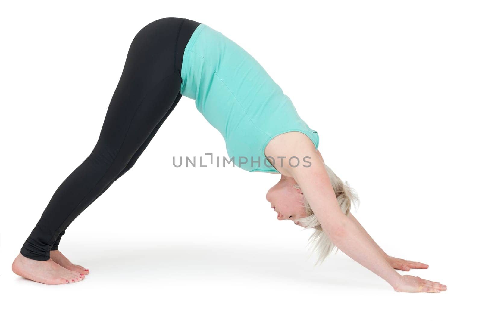 Full-body view of a young blonde woman doing yoga exercises against a white background with a slight shadow