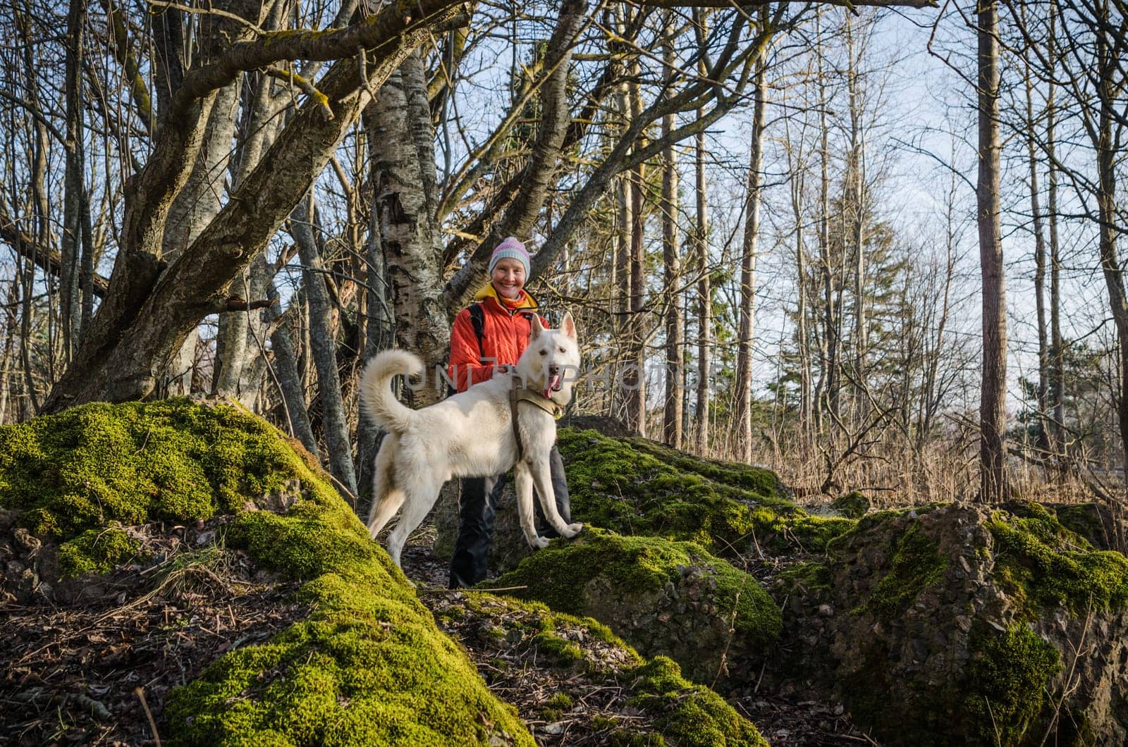 Woman with a white dog in the woods