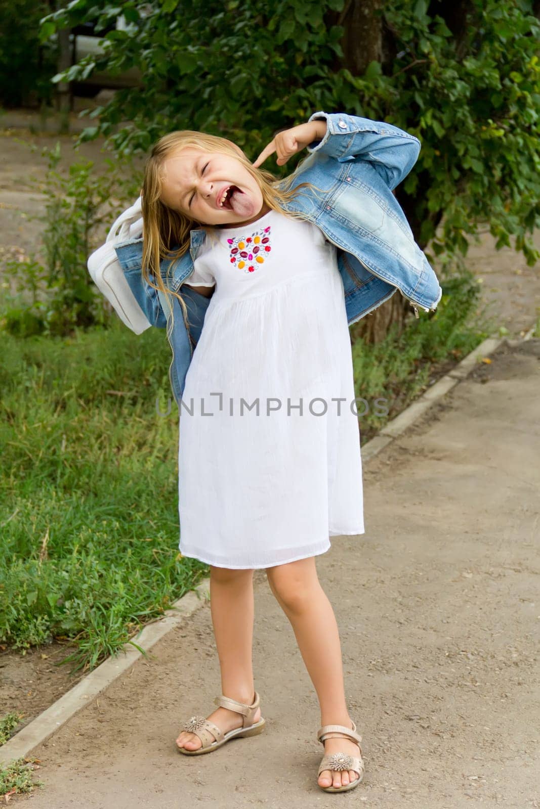 Cute girl makes faces and put out tongue