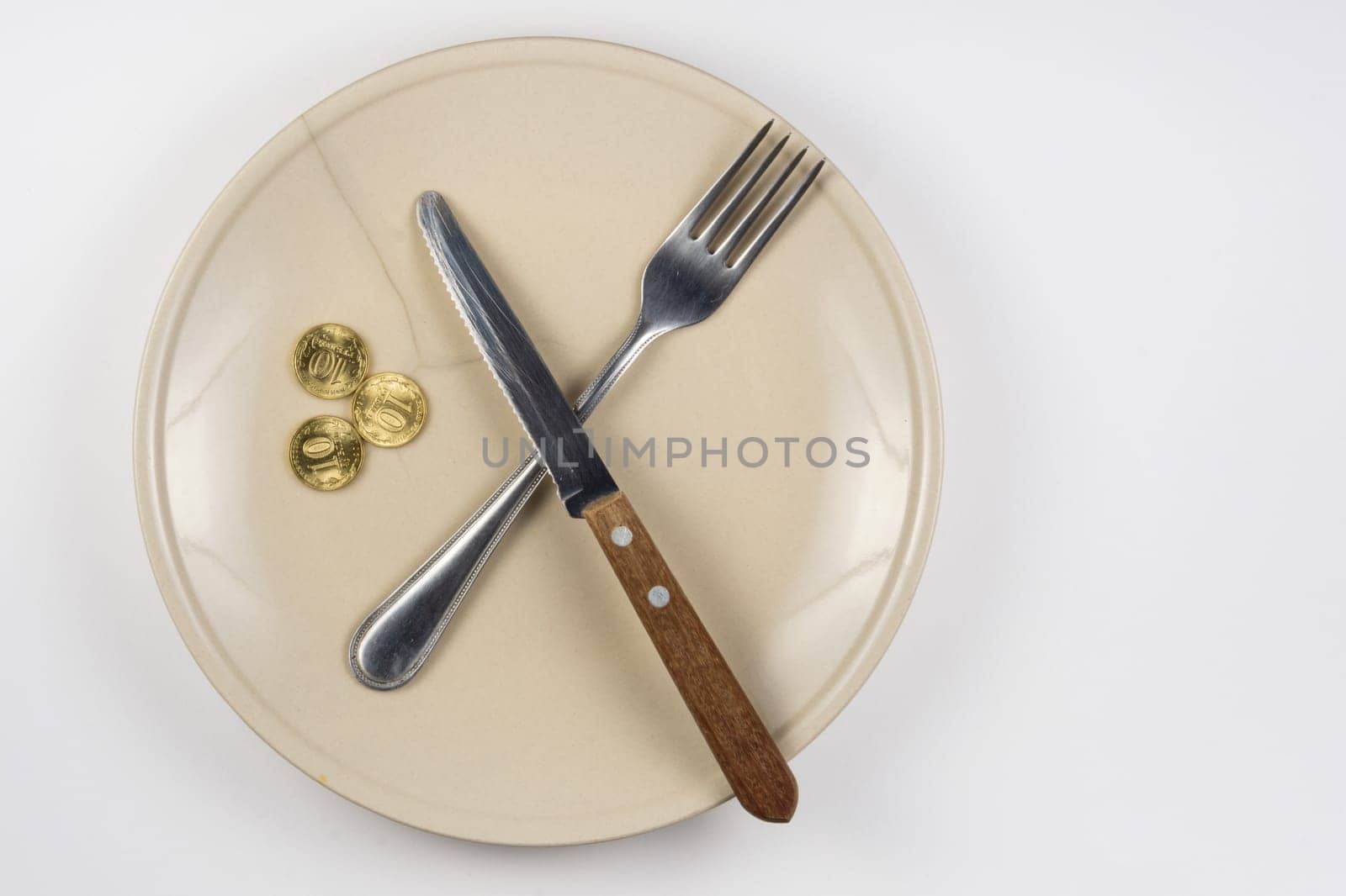 An empty cracked plate with knife and fork, it is based on three ten-coin