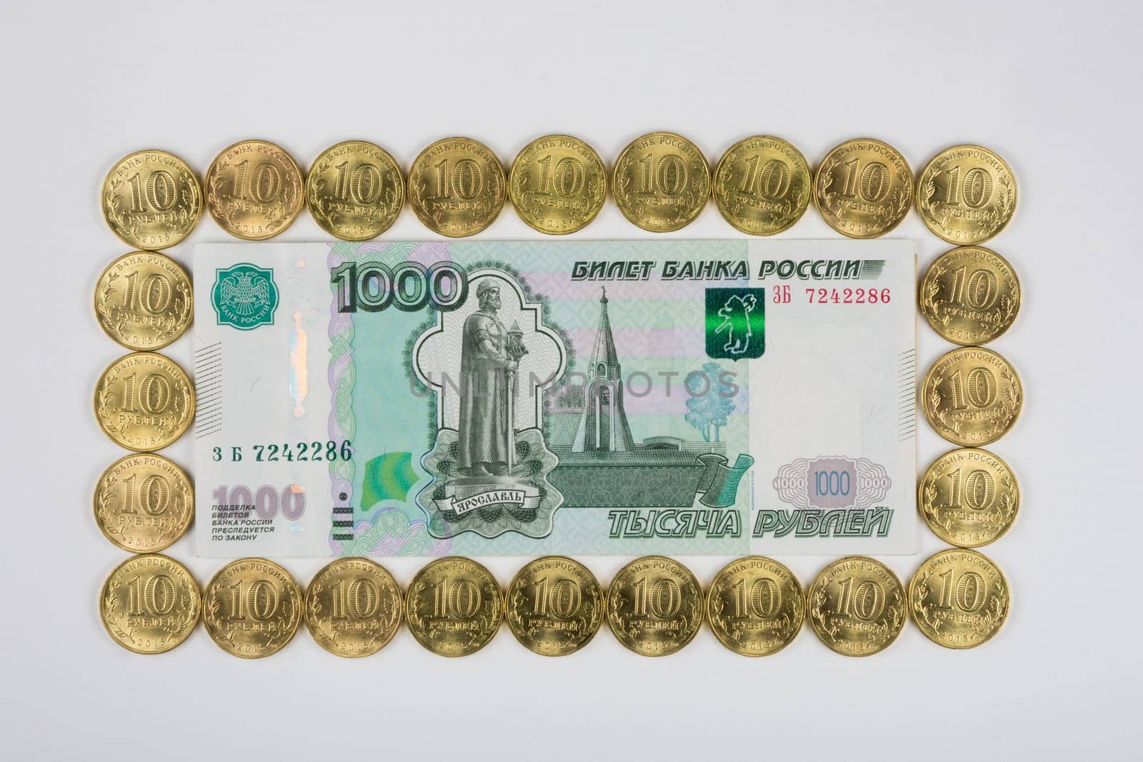 Russian thousandth banknote is imposed on a ten coins perimeter