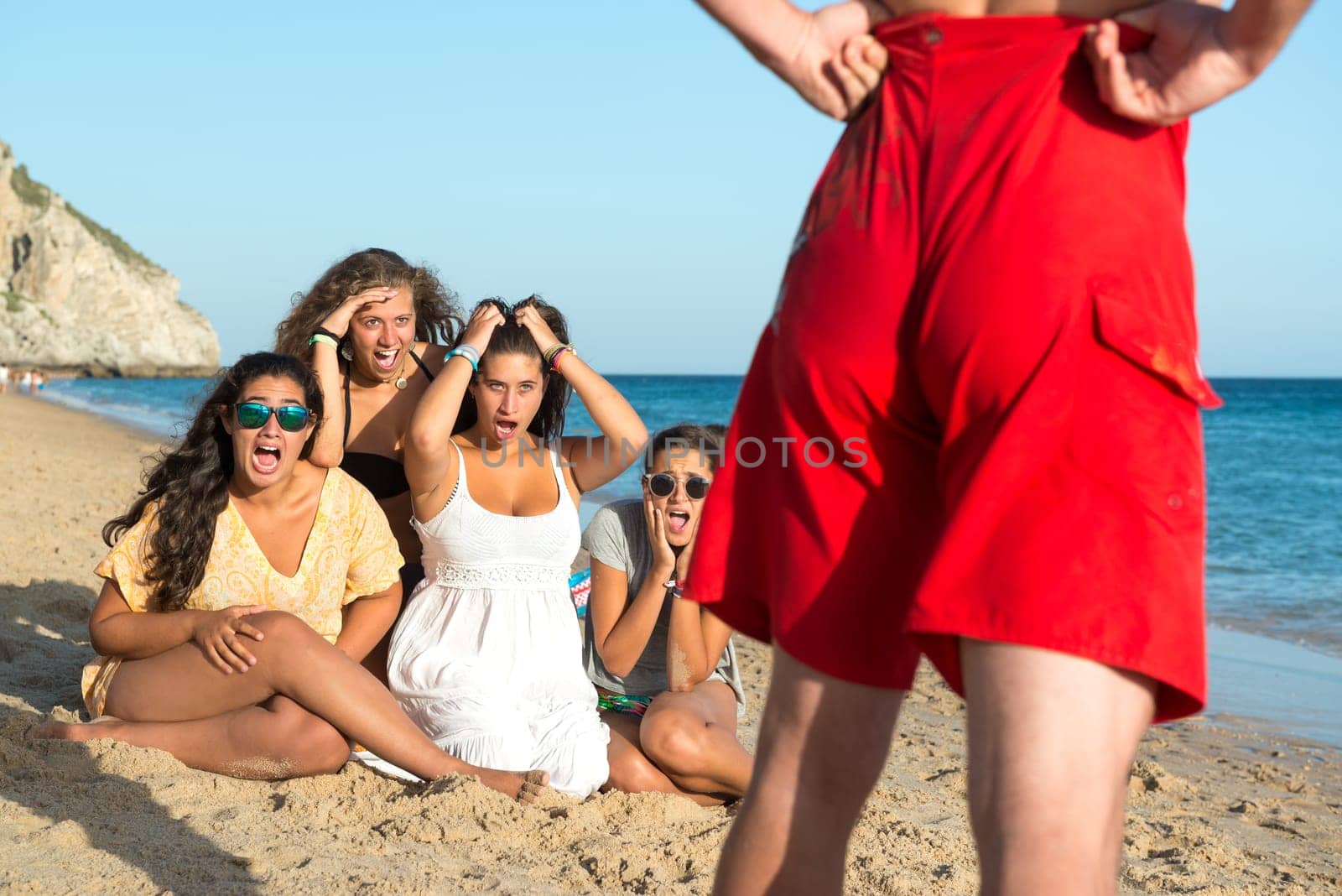 Group of girls checking a boy in the beach
