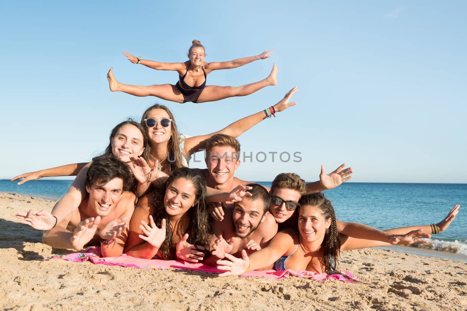 Group of happy teenage friends having fun at the beach